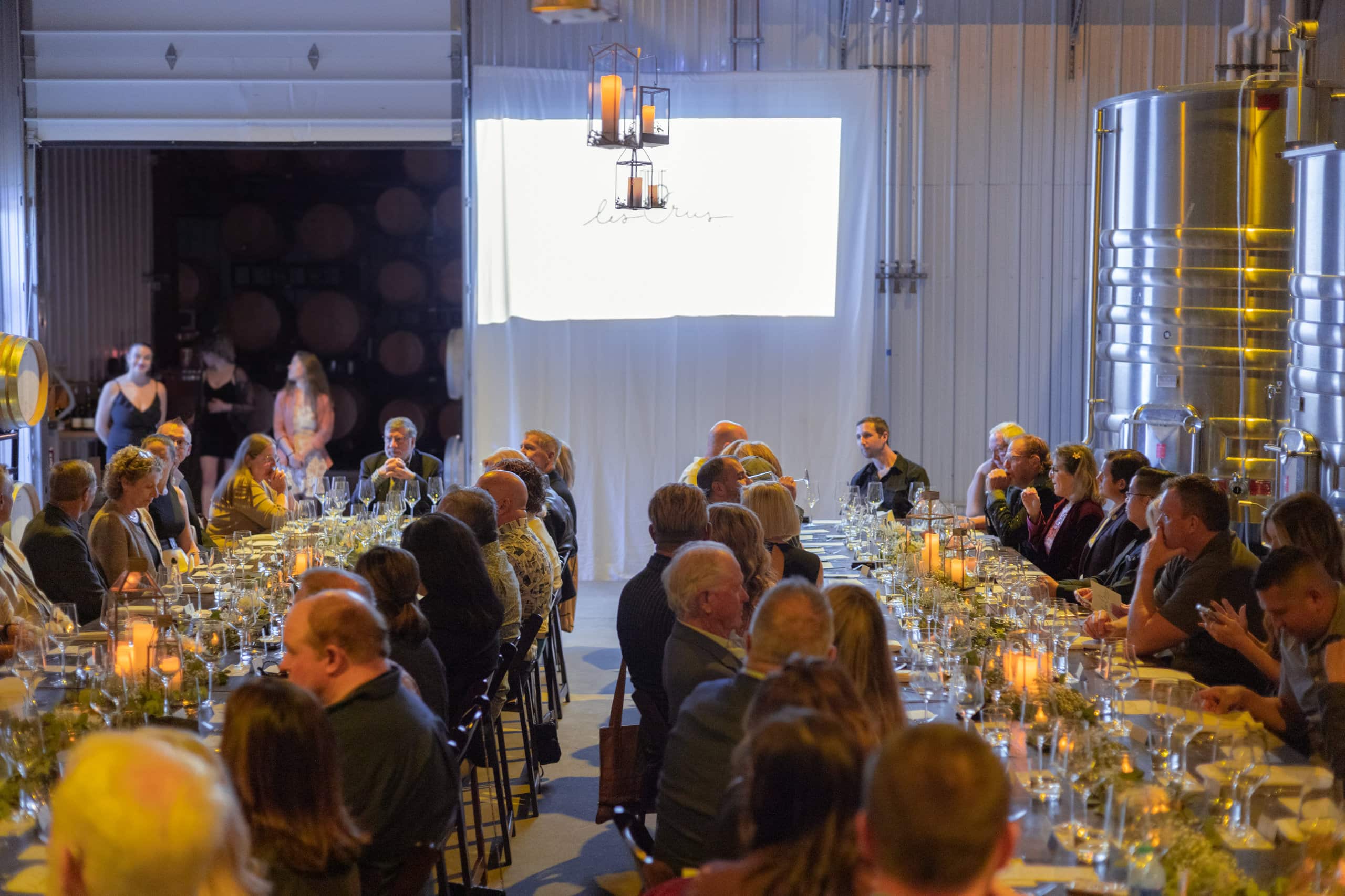 Two long tables filled with wine club members at a BENOM event
